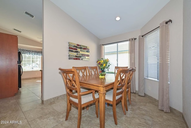 tiled dining area with plenty of natural light and lofted ceiling