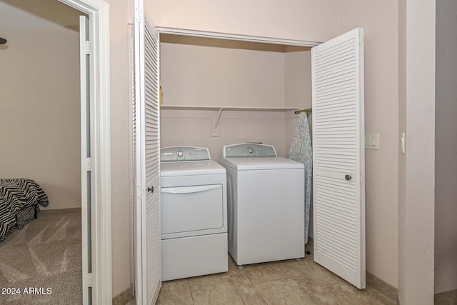 laundry room with independent washer and dryer and light tile patterned floors