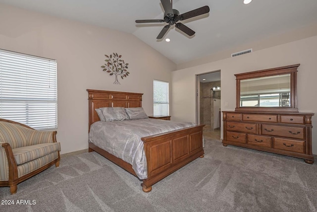 bedroom featuring light carpet, ensuite bathroom, vaulted ceiling, and ceiling fan