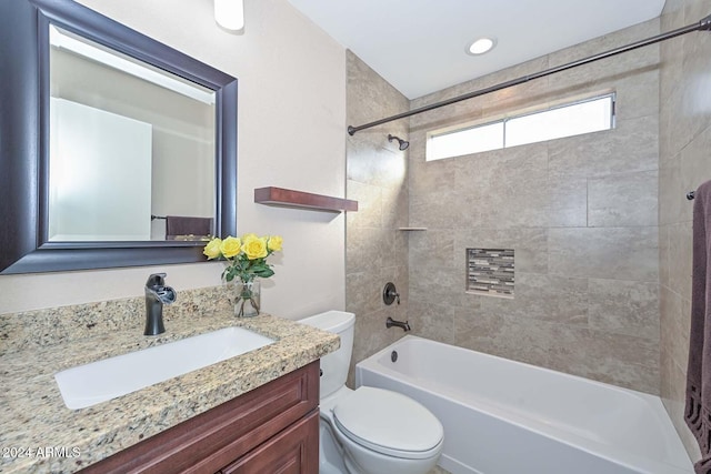 full bathroom featuring tiled shower / bath combo, toilet, and vanity