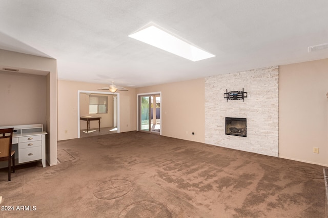 unfurnished living room featuring ceiling fan, carpet, and a fireplace