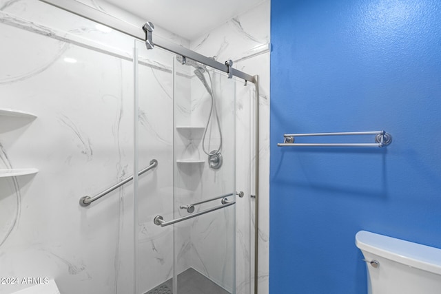 bathroom with toilet and a shower with door