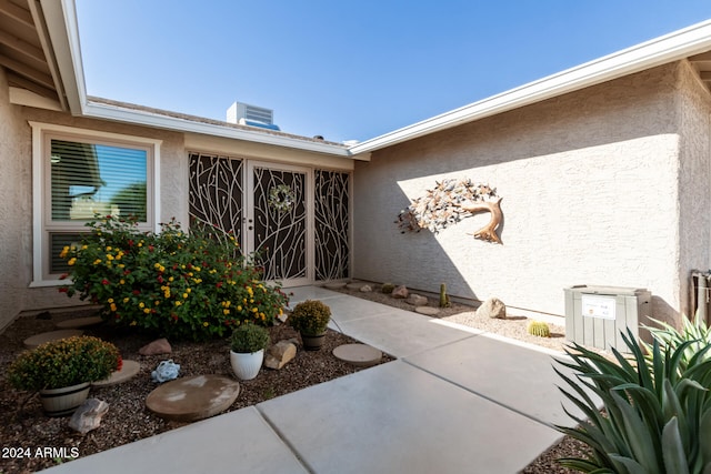 entrance to property featuring central AC unit and a patio