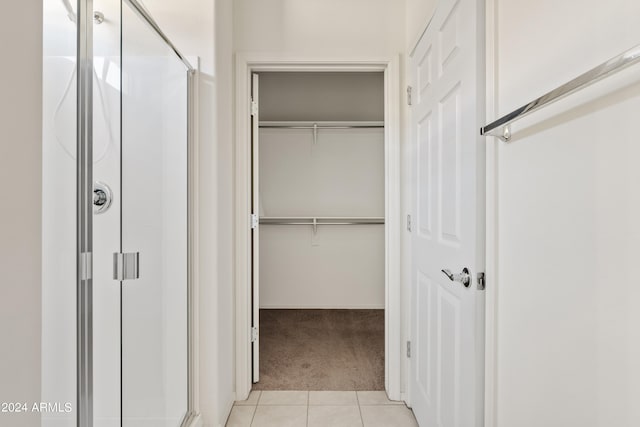 interior space featuring a shower with door and tile patterned flooring