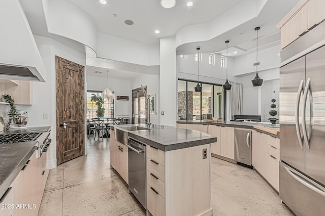 kitchen featuring appliances with stainless steel finishes, modern cabinets, light brown cabinets, custom range hood, and recessed lighting