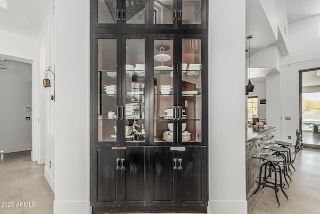 bar with baseboards and concrete floors