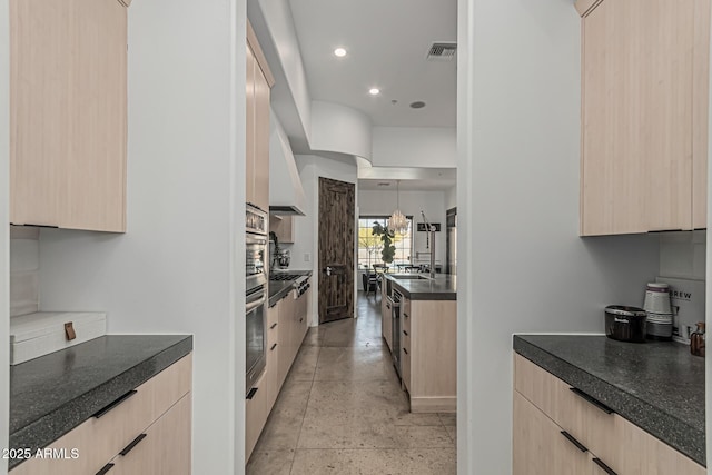 kitchen featuring light brown cabinetry, dark countertops, and modern cabinets