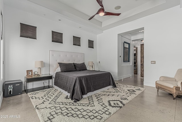 bedroom featuring baseboards, ceiling fan, and a tray ceiling