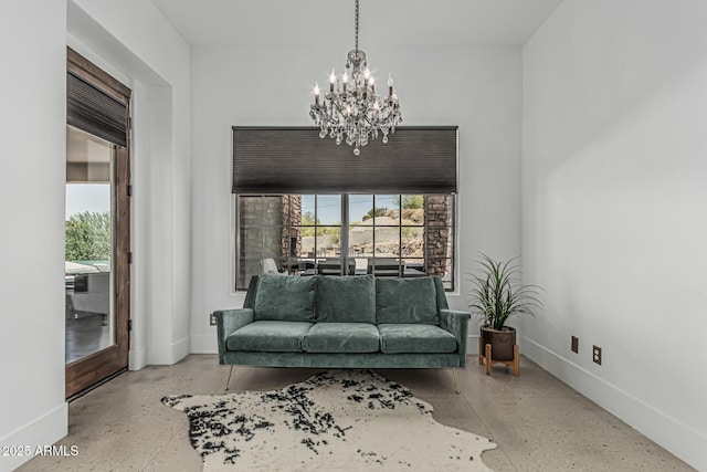 sitting room with baseboards, concrete floors, and a notable chandelier