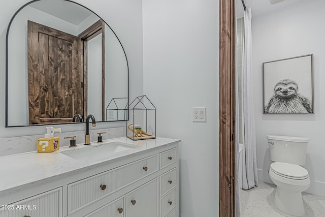 bathroom featuring vanity, baseboards, toilet, and speckled floor