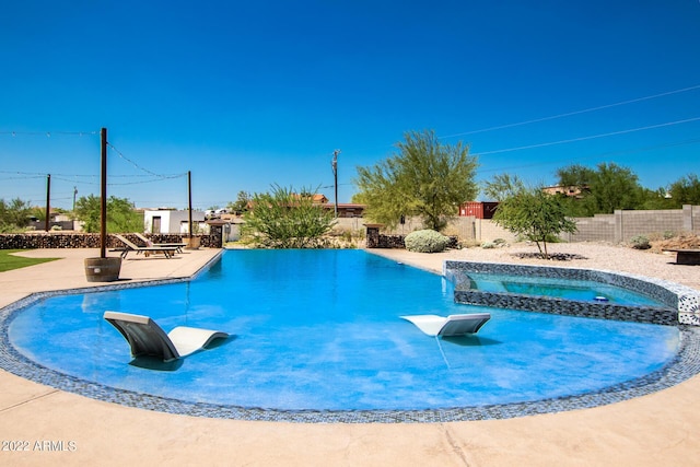 view of pool featuring a pool with connected hot tub, fence, and a patio area