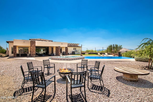 community pool featuring a fire pit and a patio area
