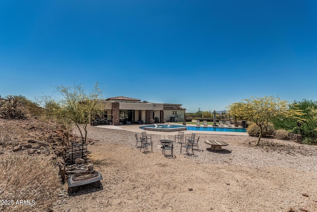 exterior space featuring a patio, a community pool, and stucco siding