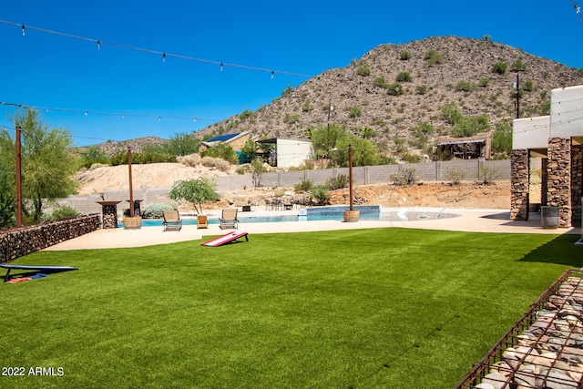 view of yard with fence, a fenced in pool, and a mountain view