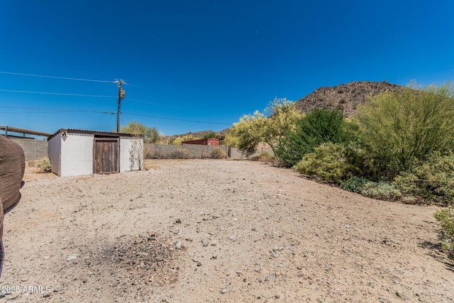view of yard with fence, an outdoor structure, and a shed