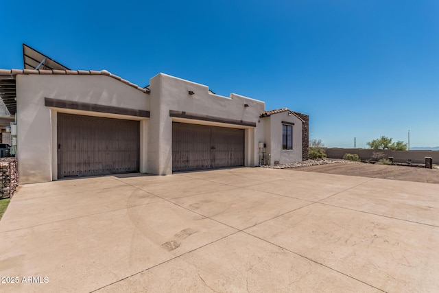 view of front facade with a garage, stucco siding, and concrete driveway