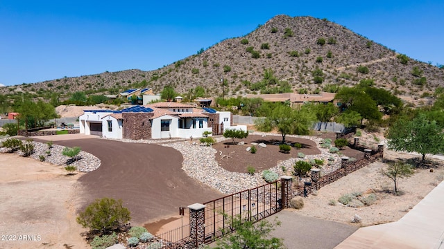 view of front facade featuring fence, a mountain view, and an attached garage