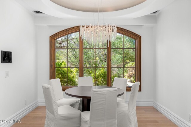 dining area featuring light hardwood / wood-style flooring, a notable chandelier, and a healthy amount of sunlight