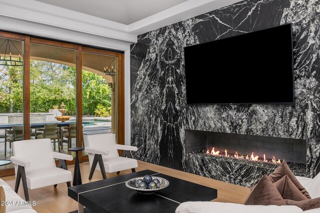 living room with a high end fireplace and hardwood / wood-style flooring