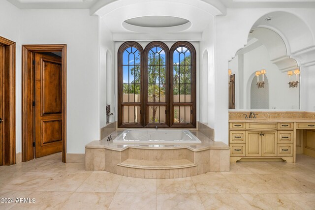 bathroom featuring tiled bath and vanity