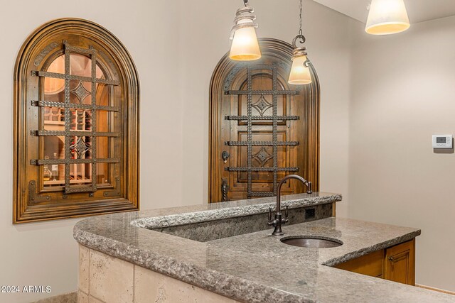 interior space featuring dark stone counters and decorative light fixtures