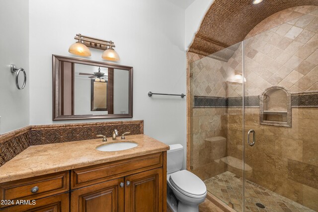 bathroom featuring vanity, toilet, and a shower with door