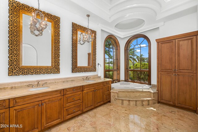 bathroom with vanity, a chandelier, and a relaxing tiled tub