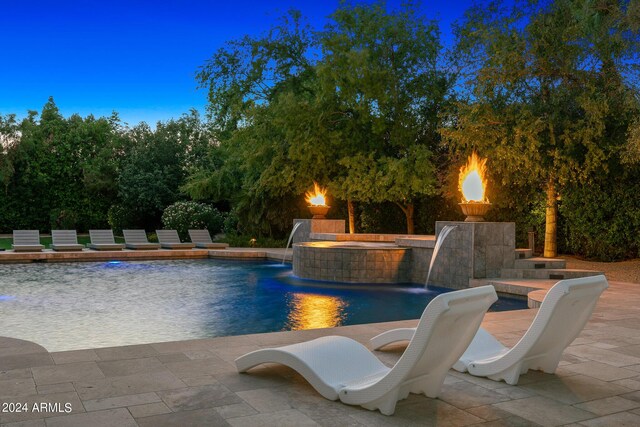 view of pool featuring a hot tub, pool water feature, and a patio area