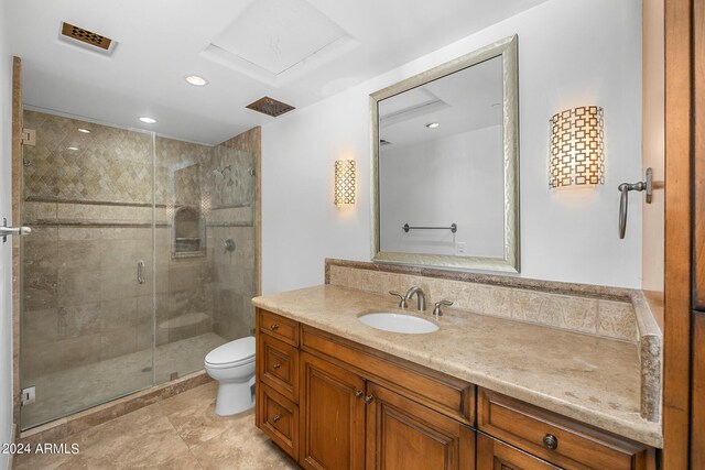 bathroom with a shower with shower door, vanity, and toilet