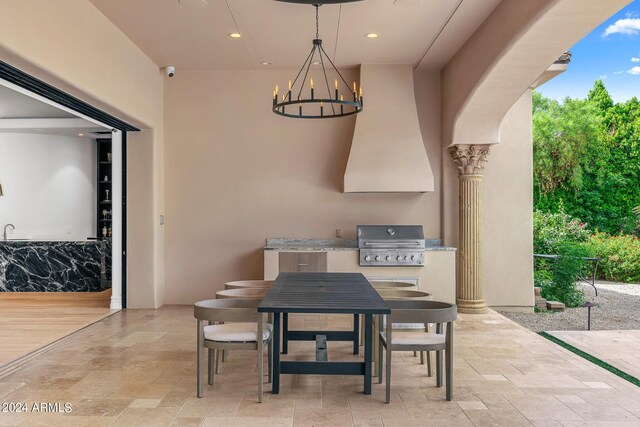 dining area featuring a notable chandelier, decorative columns, and light hardwood / wood-style floors