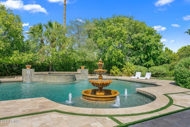 view of swimming pool with pool water feature