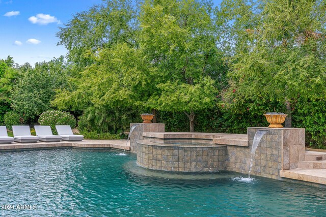 view of pool with an in ground hot tub and pool water feature