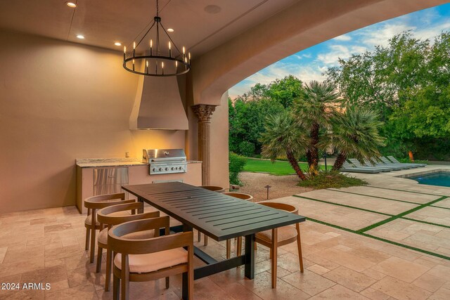 patio terrace at dusk featuring an outdoor kitchen and a grill