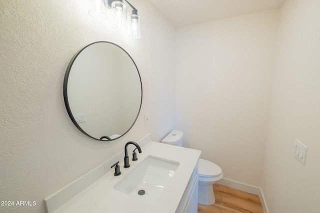 bathroom with vanity, wood-type flooring, and toilet