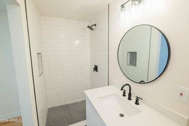 bathroom with vanity and a tile shower