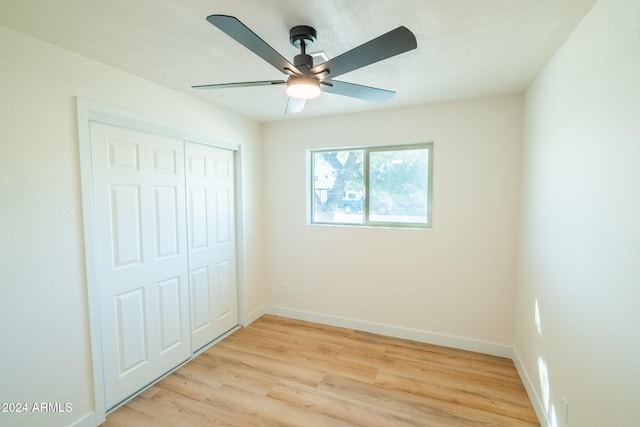 unfurnished bedroom featuring light hardwood / wood-style flooring, a closet, and ceiling fan