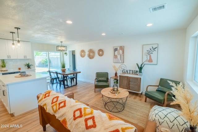 living room featuring light hardwood / wood-style flooring and an inviting chandelier