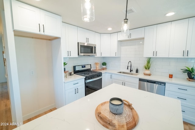 kitchen featuring pendant lighting, white cabinetry, and stainless steel appliances