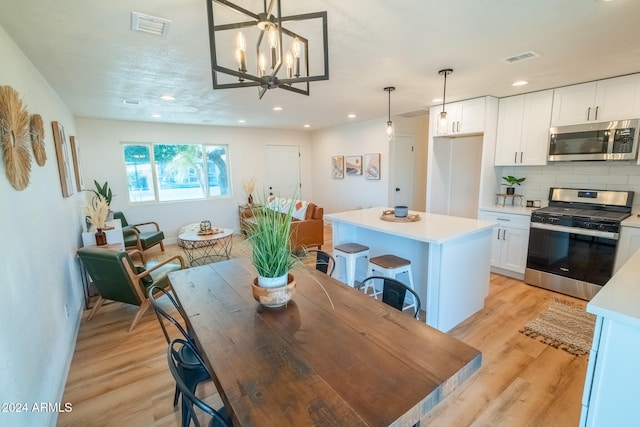 dining space featuring an inviting chandelier and light wood-type flooring