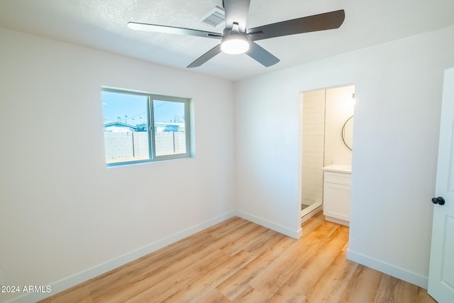 unfurnished bedroom with light hardwood / wood-style flooring, ensuite bath, and ceiling fan