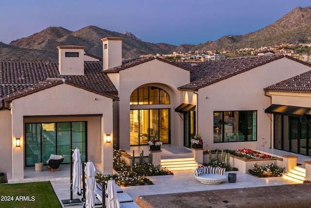 mediterranean / spanish-style home with a mountain view and a patio area