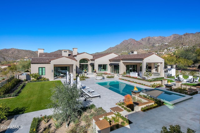 view of pool with a patio, a mountain view, and a yard