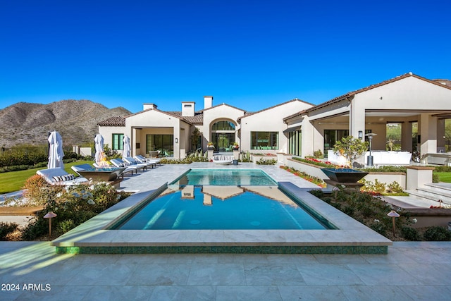 view of pool featuring a mountain view and a patio