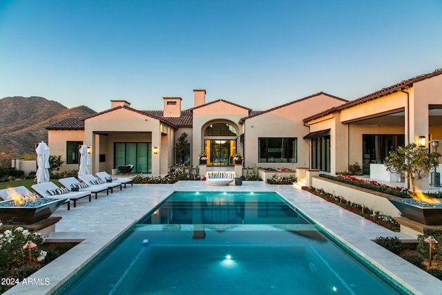 view of pool with a patio area, a mountain view, and an in ground hot tub