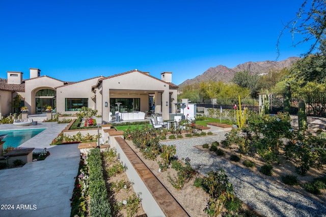 back of house featuring a mountain view, a fenced in pool, and a patio area