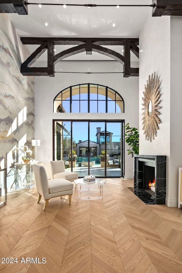 living room with light parquet flooring and a towering ceiling