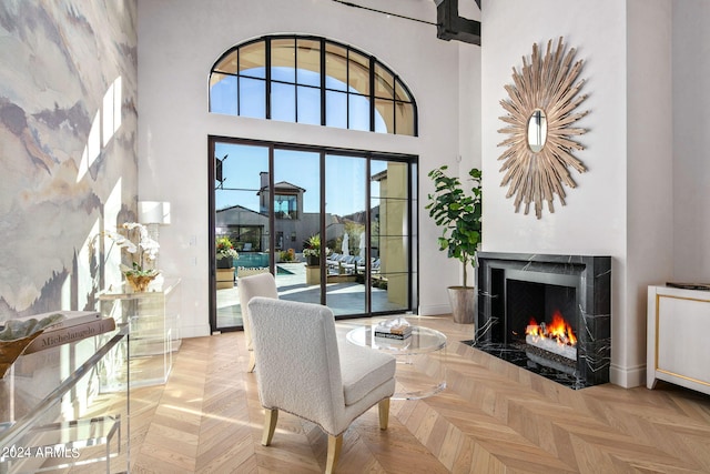 sitting room featuring a high ceiling and light parquet flooring