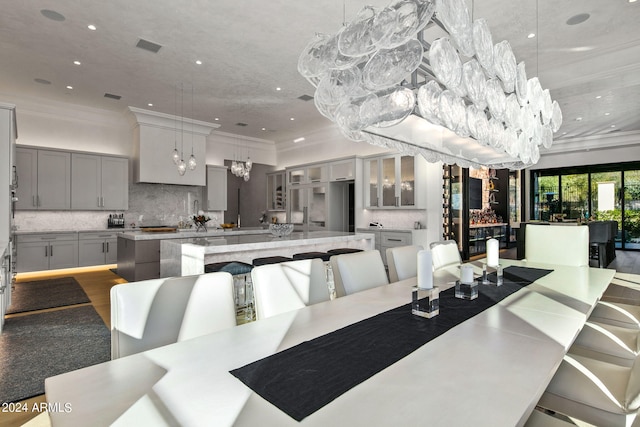 dining space with ornamental molding, wood-type flooring, and a chandelier