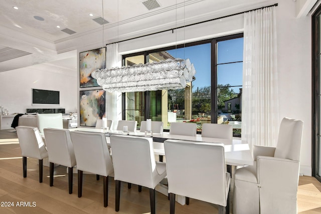 dining area featuring coffered ceiling, light hardwood / wood-style flooring, and crown molding