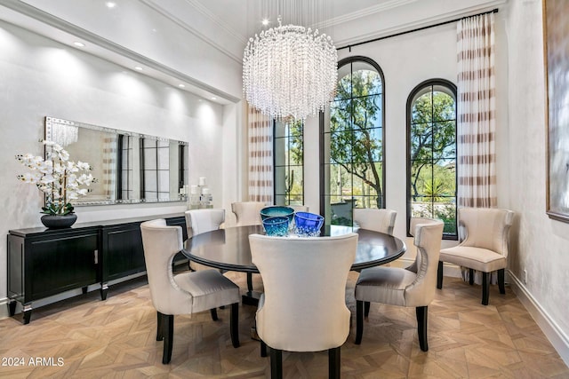 dining space featuring ornamental molding, light parquet floors, a high ceiling, and a notable chandelier